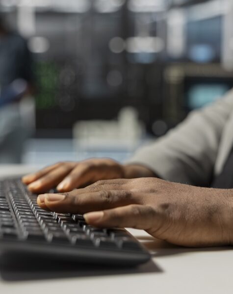 Close up of data center technician typing on keyboard, inspecting gear, doing maintenance tasks. Server farm employee coding on PC, conducting system checks to ensure operational stability