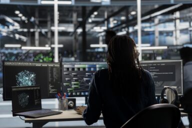 Data center worker using AI deep learning algorithms to analyze large datasets. Server farm technician using artificial intelligence and visual programming to recognize patterns in facility data
