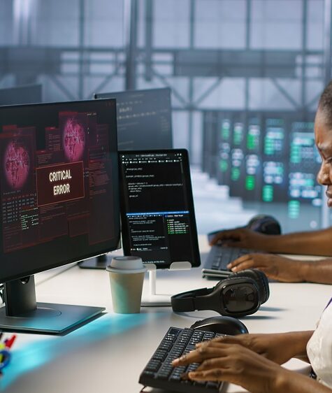 IT staff members seeing critical error popup on PC screen in data center, requesting help from cybersecurity team. Server hub coworkers struggling to eliminate cyberattacks affecting network, camera A