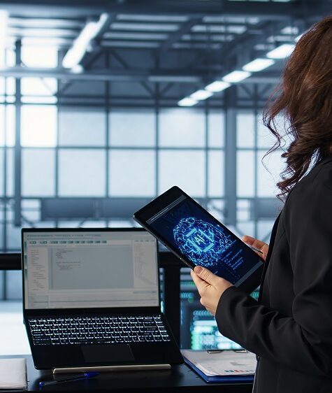 Technician in data center with tablet integrating AI driven automation tools, running predictive maintenance routines. Woman ensuring continuous uptime of server room, managing data flows, camera B